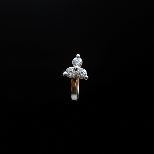 Gold ring with a diamond on a finger against a blue background