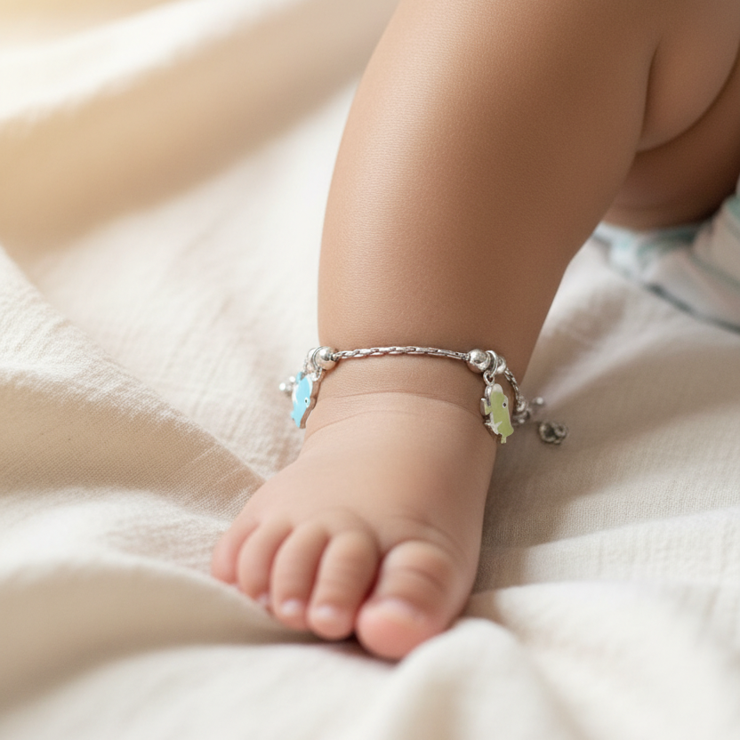 Baby's foot with a decorative anklet on a soft, light-colored fabric background