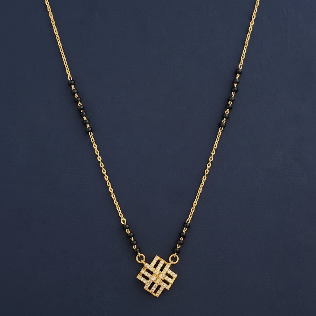 Gold and black necklace on a red fabric background