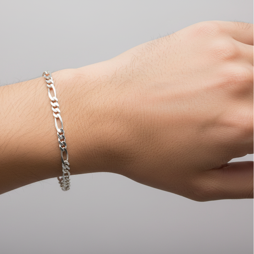 Silver bracelet on a wrist against a gray background