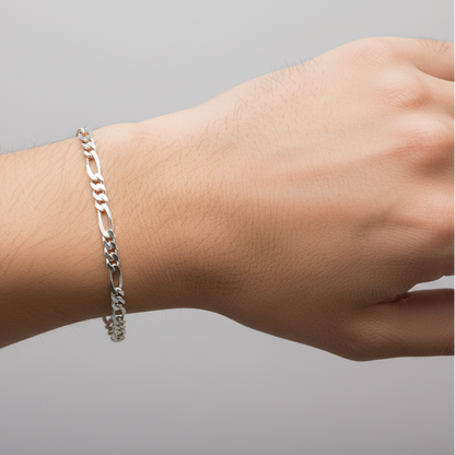 Silver bracelet on a wrist against a gray background