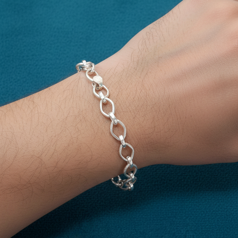 Silver chain bracelet on a wrist against a blue background