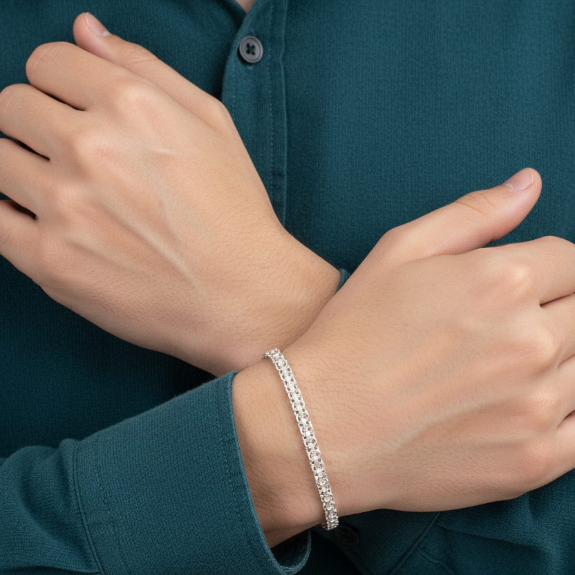 Person wearing a silver bracelet on a dark teal shirt
