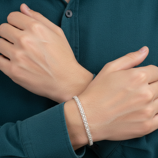 Person wearing a silver bracelet on a dark teal shirt