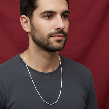 Man wearing a silver chain necklace against a red background