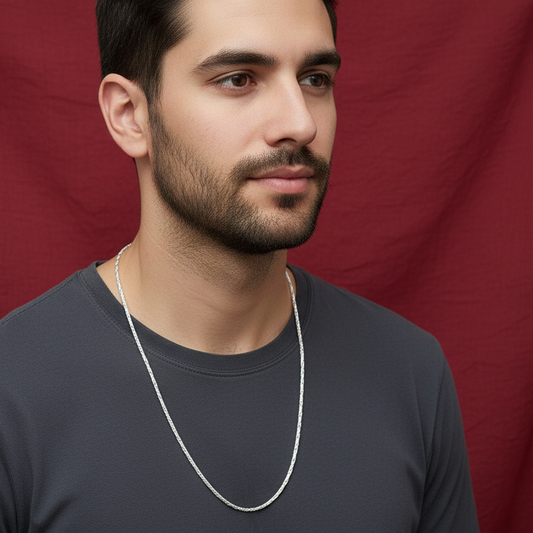 Man wearing a silver chain necklace against a red background