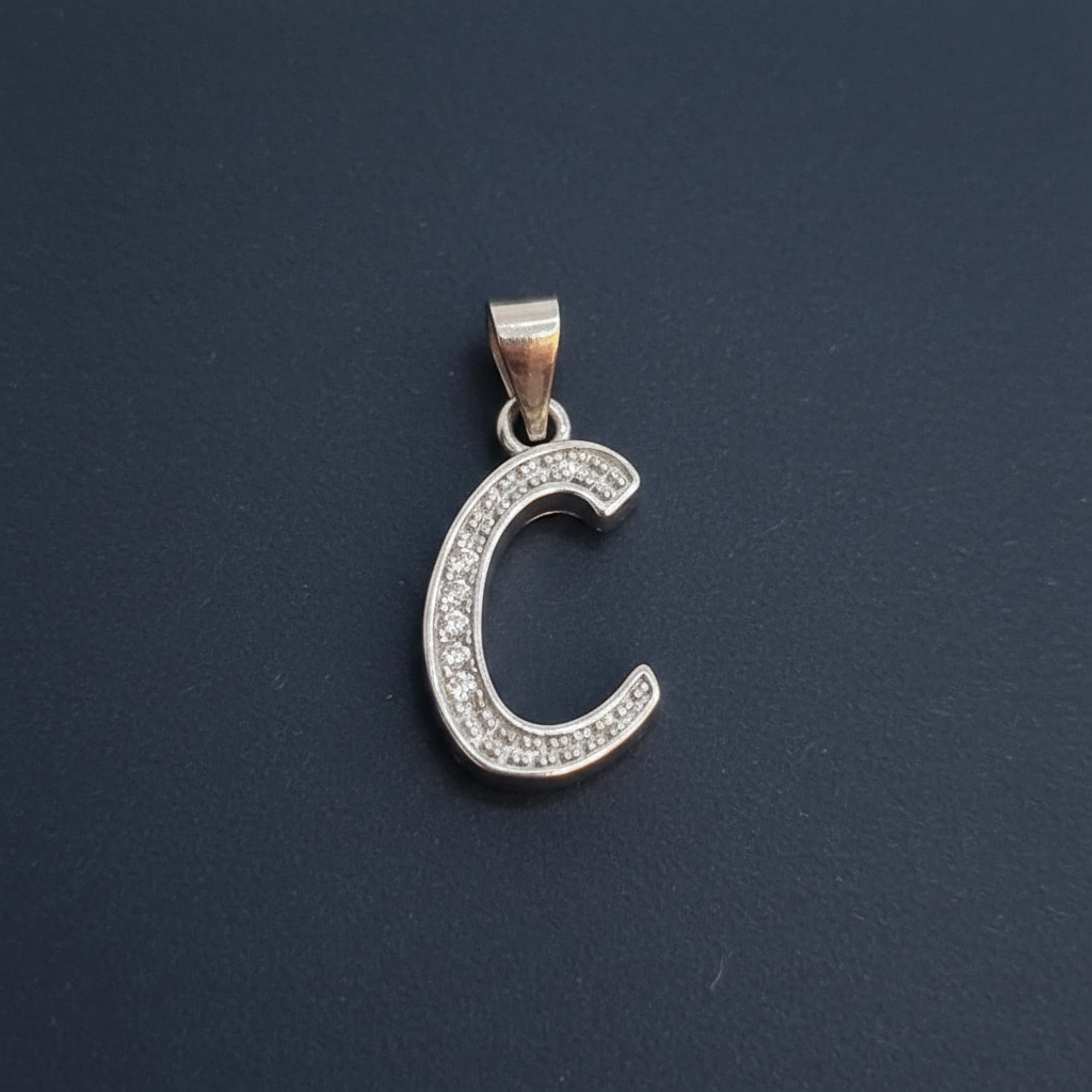 Silver crescent moon pendant with ruler for scale on a red background