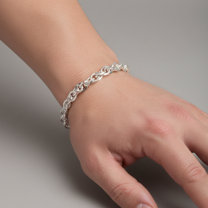 Silver bracelet on a person's wrist against a gray background