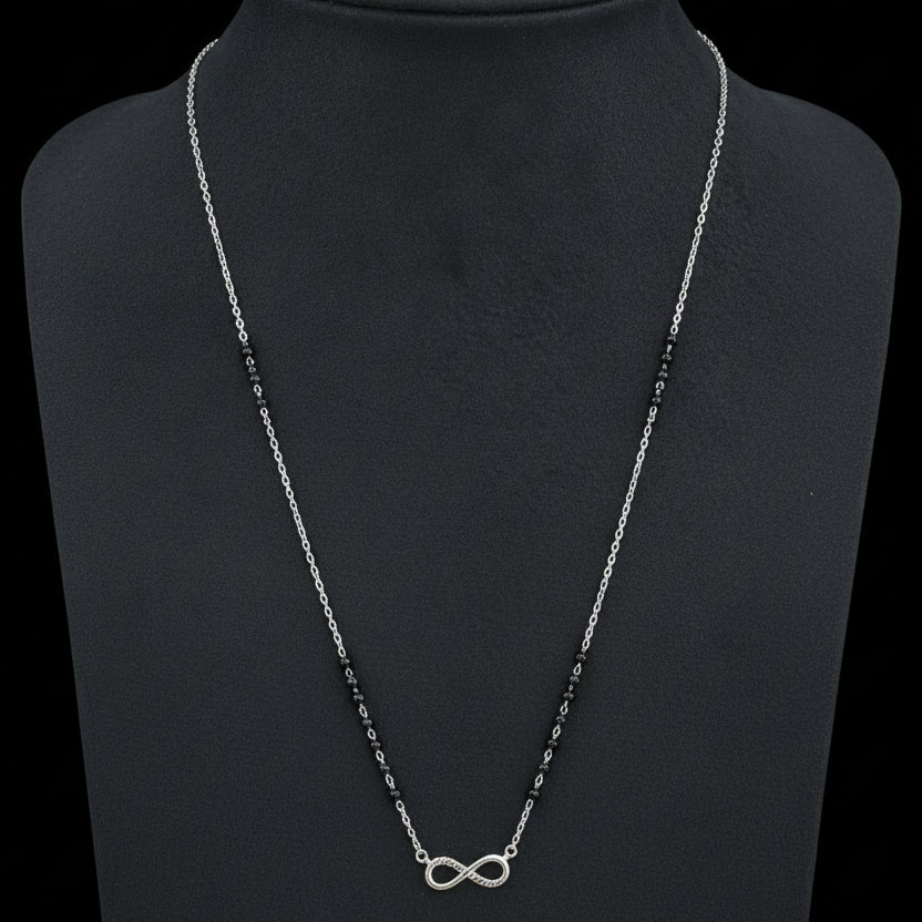 Necklace with an infinity symbol pendant on a red fabric background