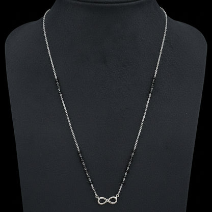 Necklace with an infinity symbol pendant on a red fabric background