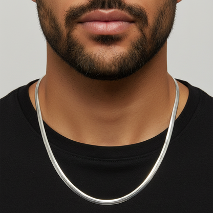 Man wearing a silver necklace against a neutral background