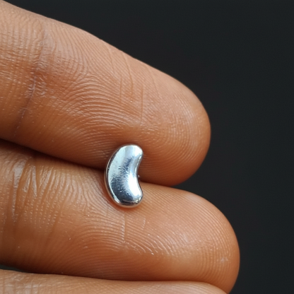 Silver ring on a person's finger with a red fabric background