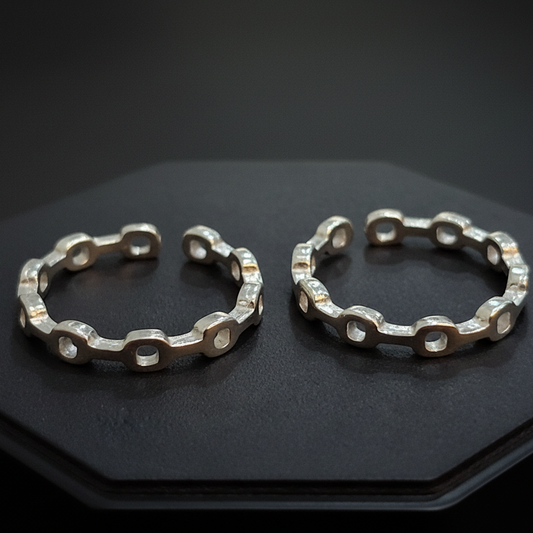 Gold hoop earrings on a black stand with a pink background