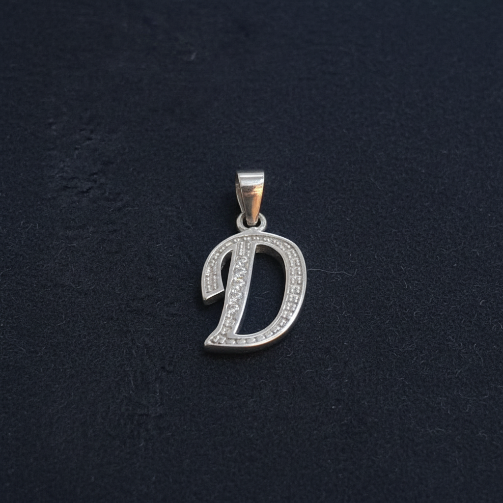Silver pendant with ruler for scale on a red background