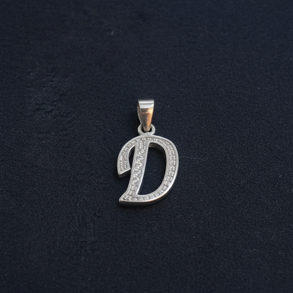 Silver pendant with ruler for scale on a red background