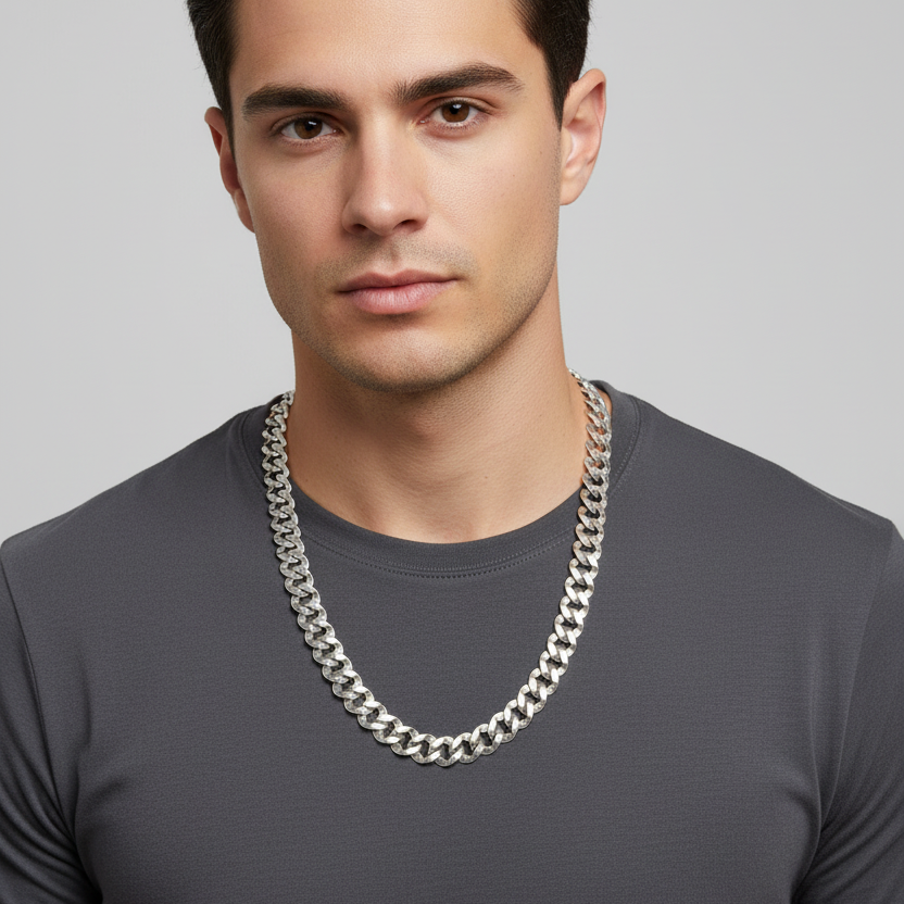 Man wearing a silver chain necklace against a gray background