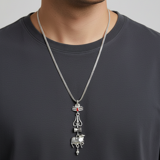 Man wearing a dark gray shirt with a silver necklace featuring a pendant.