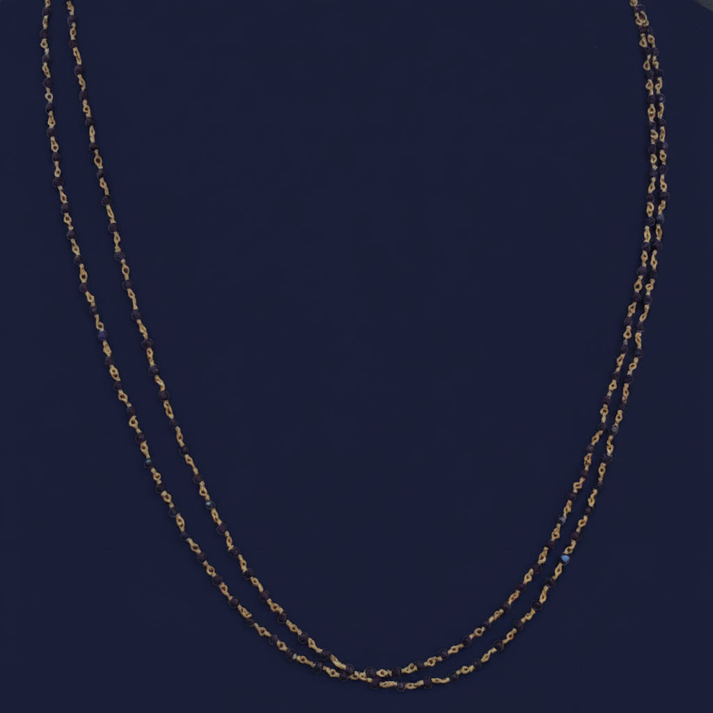 Close-up of a red fabric surface with gold stitching
