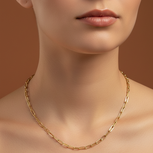 Gold necklace on a model against a brown background