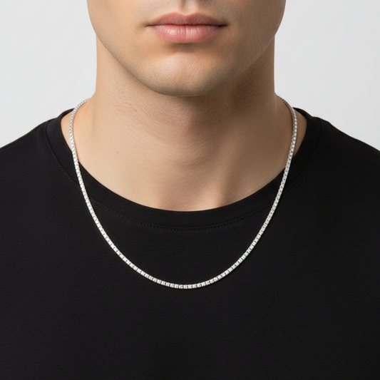 Man wearing a silver necklace against a plain background
