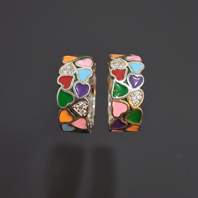 Colorful heart-shaped ring on a finger with a pink background