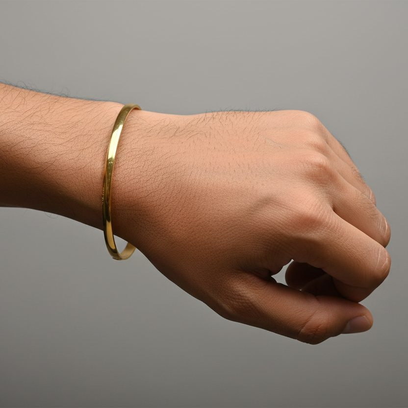 Hand wearing a gold bracelet on a gray background
