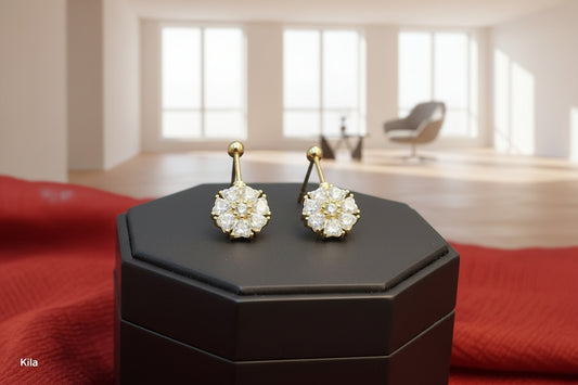 Pair of gold and crystal earrings on a dark gray stand with a red fabric background