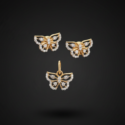 Gold butterfly earrings with diamond accents held between fingers against a red fabric background