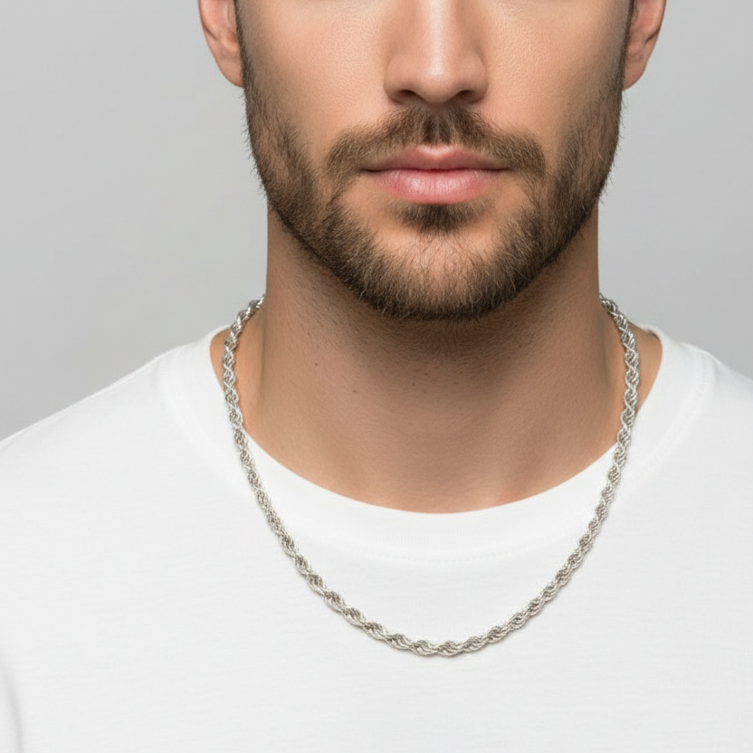 Man wearing a silver chain necklace against a gray background
