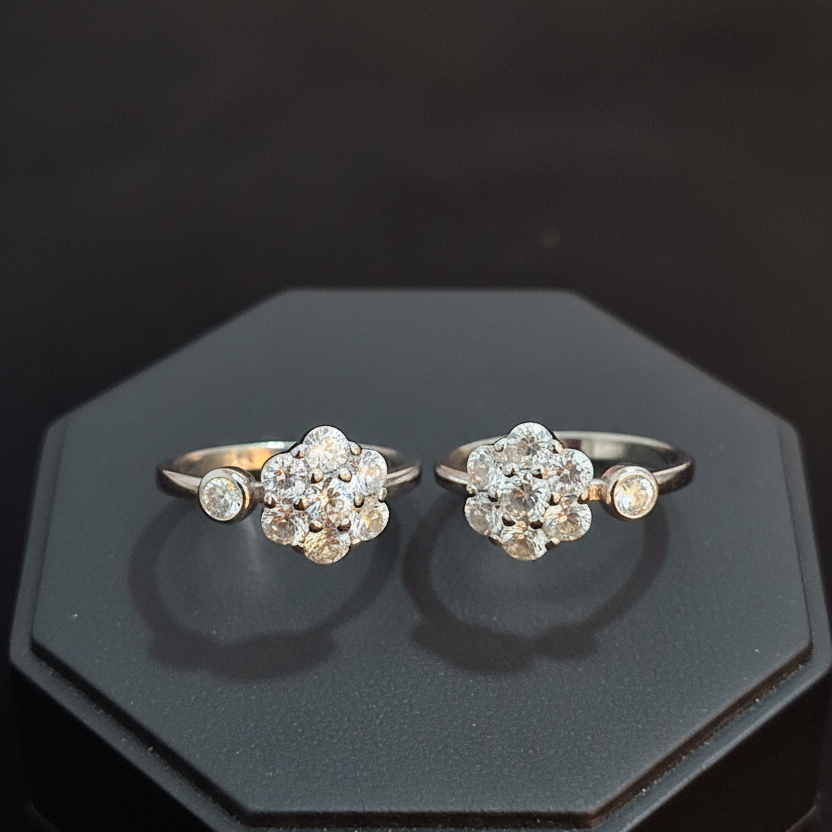 Two diamond rings on a finger against a pink background
