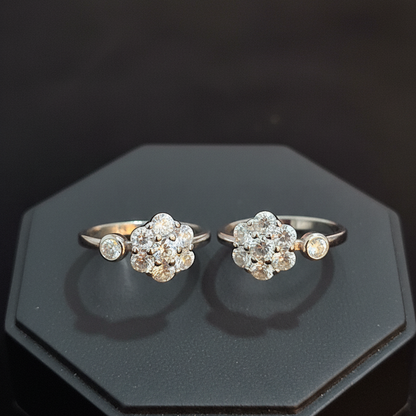Two diamond rings on a finger against a pink background
