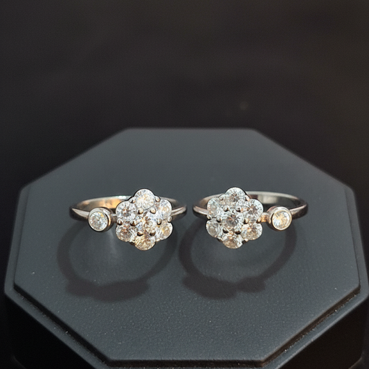 Two diamond rings on a finger against a pink background