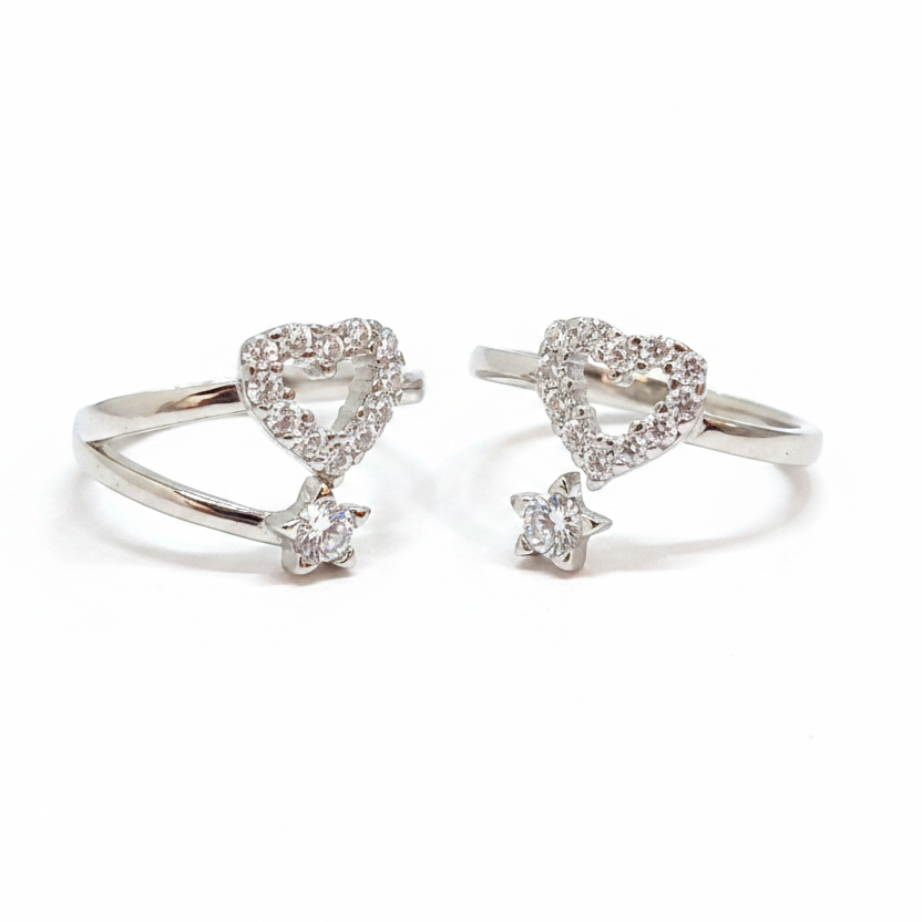 Two diamond-studded heart-shaped rings on a black stand with a pink background