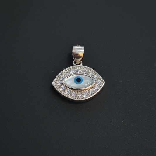 Silver pendant with blue gemstone on a maroon background, next to a ruler and Kila Silver tag.
