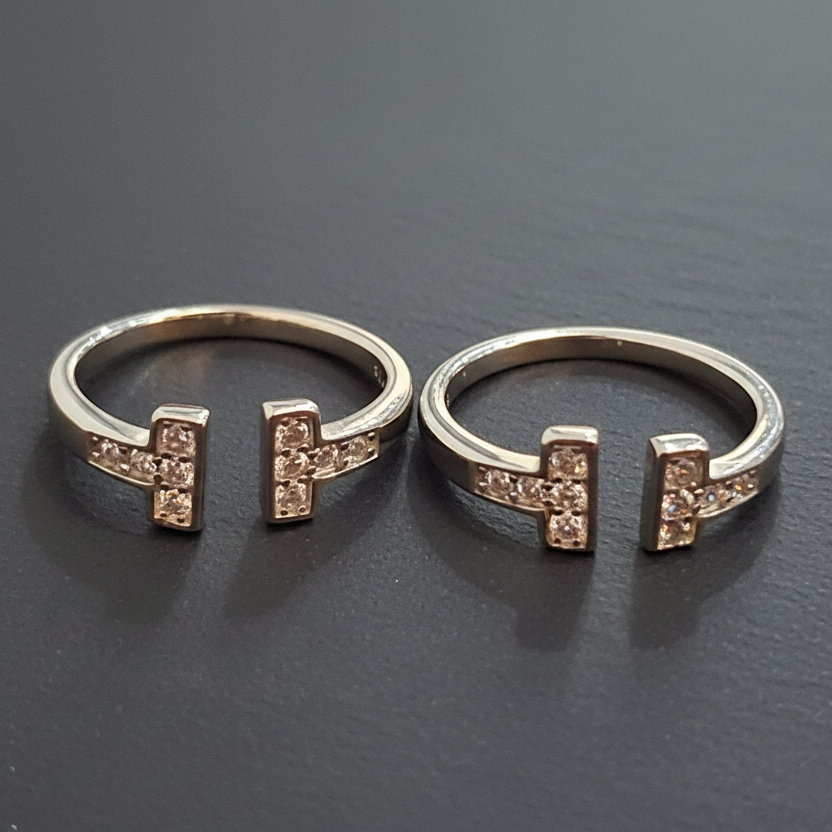 Two gold rings with pink gemstones on a black stand against a pink background
