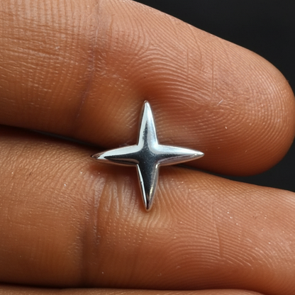Silver star-shaped ring on a finger with a red background