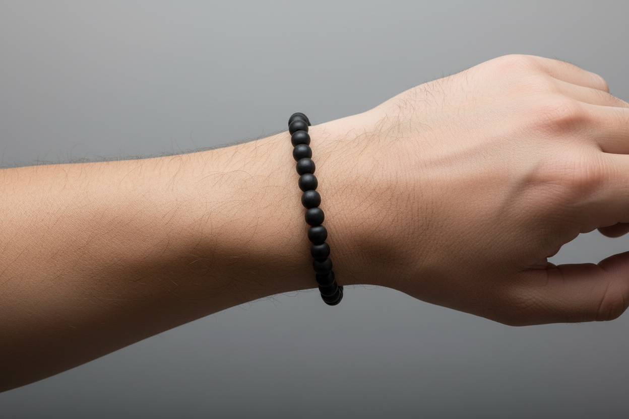 Black beaded bracelet on a light gray background