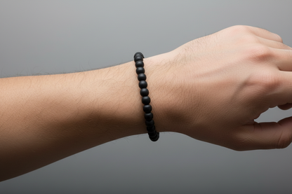 Black beaded bracelet on a light gray background
