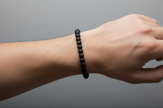 Black beaded bracelet on a light gray background