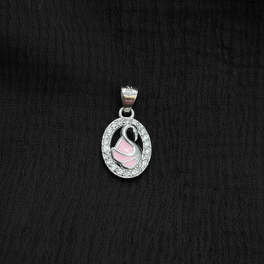 Silver charm with pink heart on a red fabric background