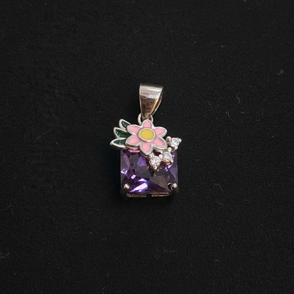Small decorative item with a purple gemstone on a red background, accompanied by a ruler for scale.