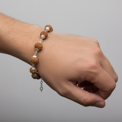 Hand wearing a beaded bracelet on a plain background