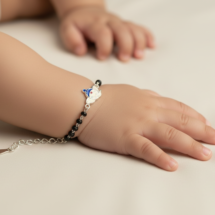 Child's hand wearing a bracelet with a small animal charm on a neutral background