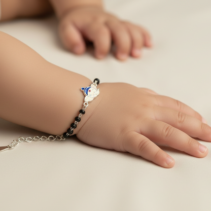 Child's hand wearing a bracelet with a small animal charm on a neutral background