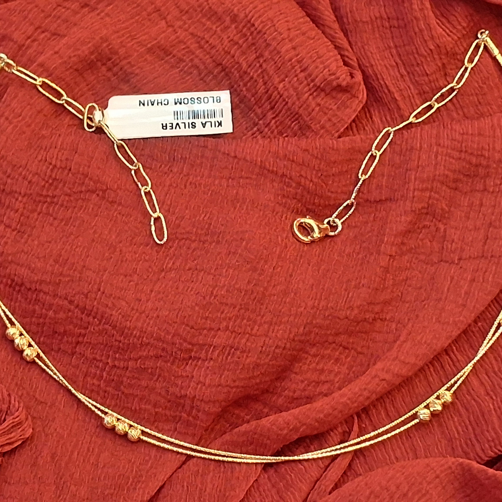 Gold necklace on a red fabric background