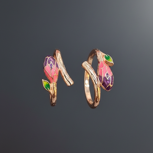 Three colorful rings on a finger against a pink background