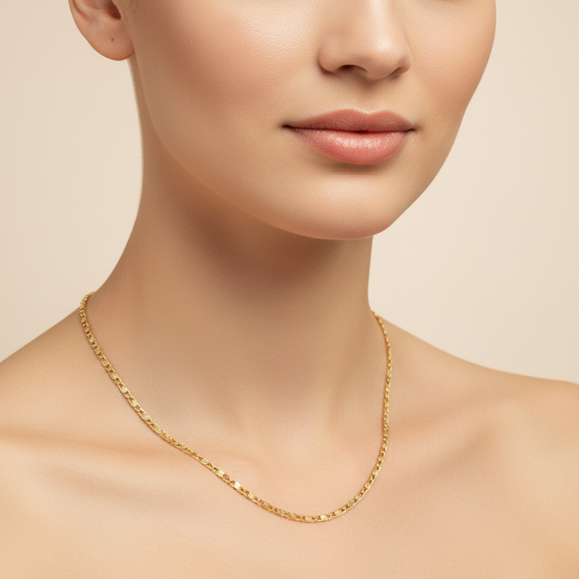 Gold necklace on a model against a beige background