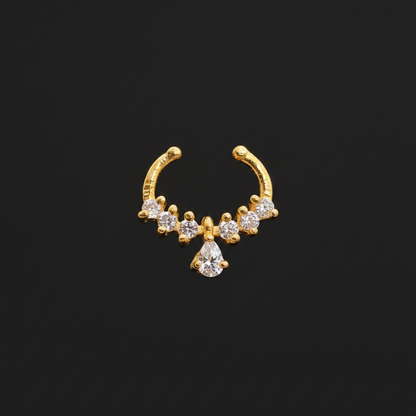 Gold nose ring with small diamonds on a teal textured background