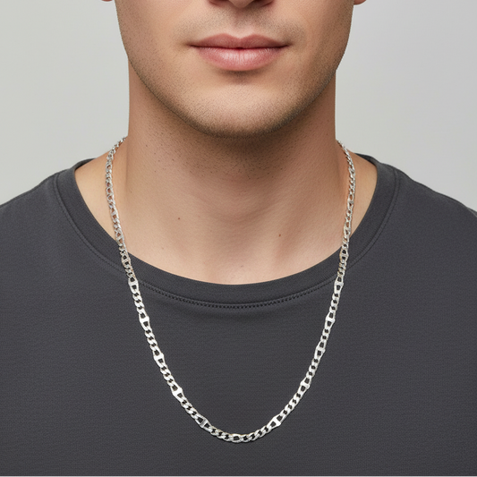 Man wearing a silver chain necklace against a plain background