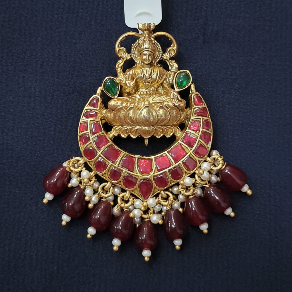 Decorative gold and red pendant with a label on a maroon background